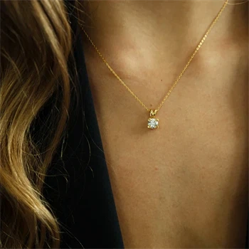 Et vedhæng med en labgrown diamant hænger i en fin, gylden kæde om halsen.
