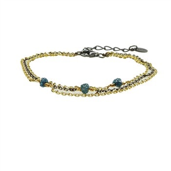Treradet armbånd i guld/sort med blå-grønne rå diamanter og mørk forlængerkæde til justering.
