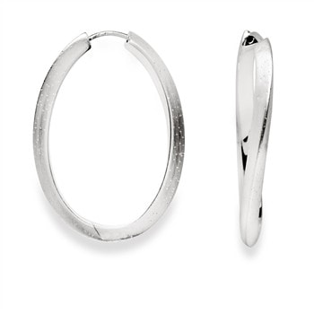 Ovalformede creoler i sterling sølv med mat finish, små prikker og synligt design fra siden.