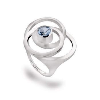 Sterling sølv ring med central blå topaz, omgivet af matte, cirkulære bånd og glat poleret struktur.