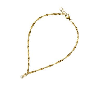 Elegant armbånd med snoet guldkæde, enkelt hvid perle og justerbart lukkesystem.