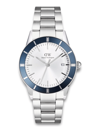 Daniel Wellington-ur med blå bezel, hvid urskive, sølvmarkeringer og metalrem. Dato ved kl. 3.