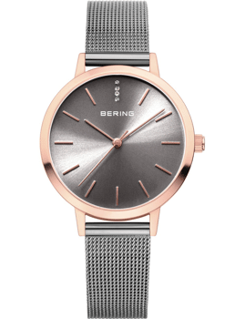 Elegant Bering dameur med sunburst urskive, metal mesh armbånd og krystaller ved 12-timers positionen.